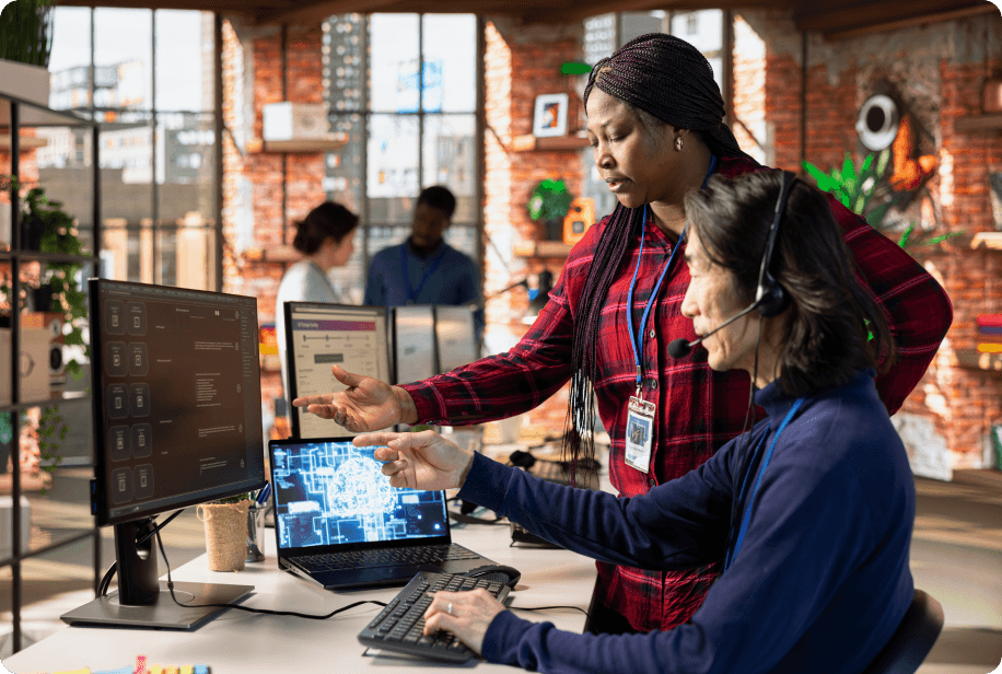 Two professionals discussing e-commerce strategy in front of a computer monitor